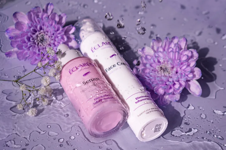 Éclarén: Serum and Face Cream on a wet surface between chrysanthemums