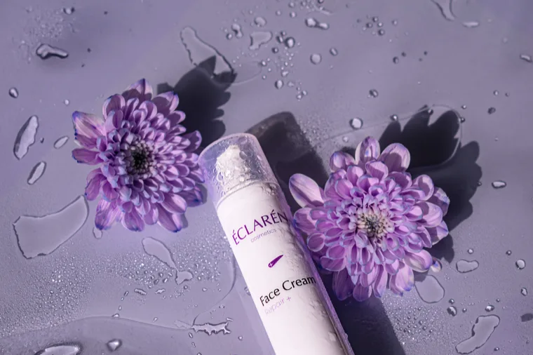 Éclarén: Face Cream between two chrysanthemums, water drops on the surface